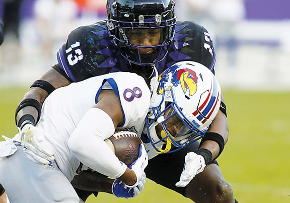 TCU's Dee Winters tackles Kansas receiver Kwamie Lassiter.